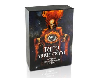 May include: A rectangular deck box featuring a dark space background with a central figure engulfed in orange flames. The figure has a large eye on its chest and the text "ТАРО ЛЮЦИФЕРА" and "ДРЕВНЯЯ ЧЕРНОМАГИЧЕСКАЯ СИСТЕМА" printed in white on the front.