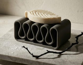 Modern minimalist-style soap dish, available in various sizes and colors, made from eco-friendly, bio-based materials.
