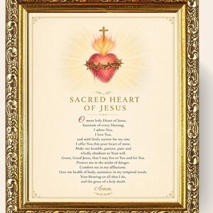 Op de afbeelding: Een ingelijste print met het Heilig Hart van Jezus met een doornenkroon en een kruis, omringd door een gouden licht. Onder de illustratie staat de tekst Sacred Heart of Jesus gevolgd door een gebed in het Engels, in een sierlijke gouden lijst.