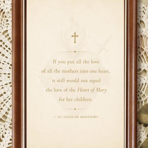 May include: A rectangular wooden frame with a dark brown finish containing a cream-colored print. The text reads: If you put all the love of all the mothers into one heart, it still would not equal the love of the Heart of Mary for her children. - ST. LOUIS DE MONTFORT. A faint image of a heart with a cross and sword is visible behind the text.