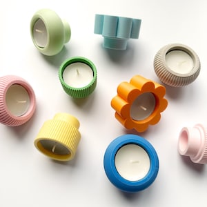 Op de afbeelding: Een set van drie keramische mokken met een gespikkelde, matte afwerking. De mokken zijn in tinten crème, lichtgrijs en donkergrijs. Elke mok heeft een eenvoudig, minimalistisch ontwerp en een afgeronde handgreep.