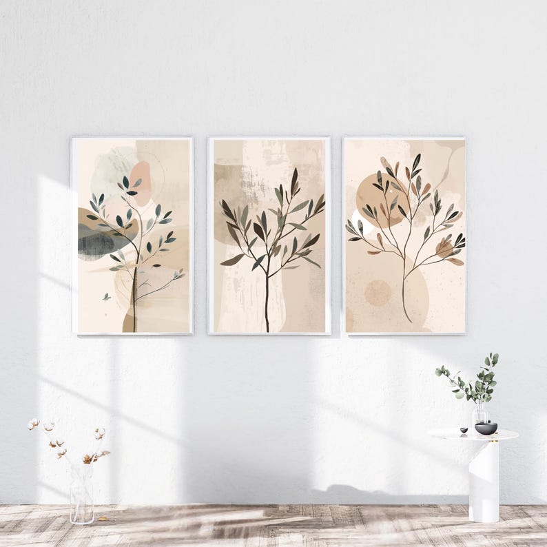 May include: Three framed botanical art prints. Each print features a minimalist design of a tree branch with leaves in shades of brown and green against a neutral background with abstract shapes. The frames are white, and the overall aesthetic is modern and serene.
