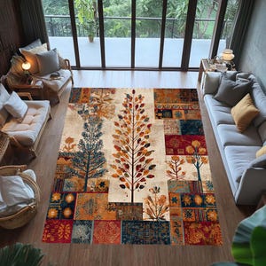 Könnte beinhalten: Ein großer Teppich mit beigem Hintergrund und einem farbenfrohen Baumdesign. Der Teppich zeigt Bäume in Blau-, Orange- und Brauntönen, vor einem Hintergrund aus gemusterten Quadraten in verschiedenen Farben. Der Teppich befindet sich in einem Wohnzimmer.