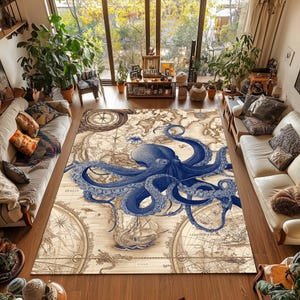 Op de afbeelding: Een groot vloerkleed met een vintage kaartontwerp en een gedetailleerde blauwe octopus illustratie. Het kleed heeft een beige achtergrond met nautische elementen zoals kompassen en zeilschepen.