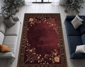 May include: A rectangular burgundy area rug with a floral design. The rug features a dark brown border with an ornate pattern and gold-colored floral accents. The rug is placed in a living room setting with two sofas and a window.