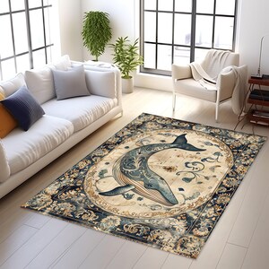 May include: A rectangular area rug featuring a whale design. The whale is depicted in shades of blue with intricate details, set against a light beige background. The rug has a dark blue and beige floral border, suitable for living room decor.