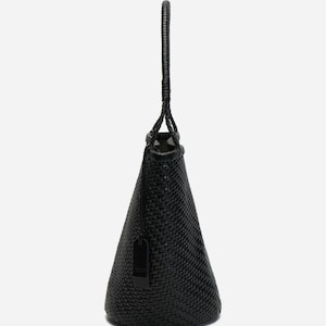 May include: Black woven tote bag with a braided handle. The bag has a conical shape and a small tag attached. The weave pattern is visible, and the bag appears to be made of a durable material.