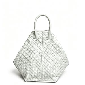 May include: A white, diamond-shaped handbag with a woven pattern. The bag features a single, rounded handle and a structured design. The material appears to be leather or a similar material. The bag is set against a plain white background.