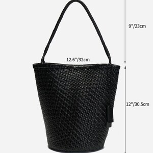 May include: Black woven tote bag with a handle. The bag is 12 inches (30.5 cm) tall, 12.6 inches (32 cm) wide, and 7.8 inches (20 cm) deep. The handle is 9 inches (23 cm) long. The bag has a tag attached.