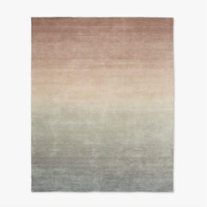 Pode incluir: Um tapete retangular com um esquema de cores gradiente. A parte superior do tapete é marrom suave, passando para um bege claro no meio e desbotando para um azul-acinzentado suave na parte inferior. O tapete tem uma aparência macia e texturizada.