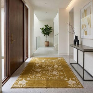 Pu&ograve; includere: Tappeto rettangolare giallo senape con un motivo floreale in un corridoio. Il tappeto ha un bordo e un motivo floreale color crema. Il corridoio presenta una porta in legno, una consolle e una pianta in vaso. Il tappeto misura circa 183 cm per 274 cm.