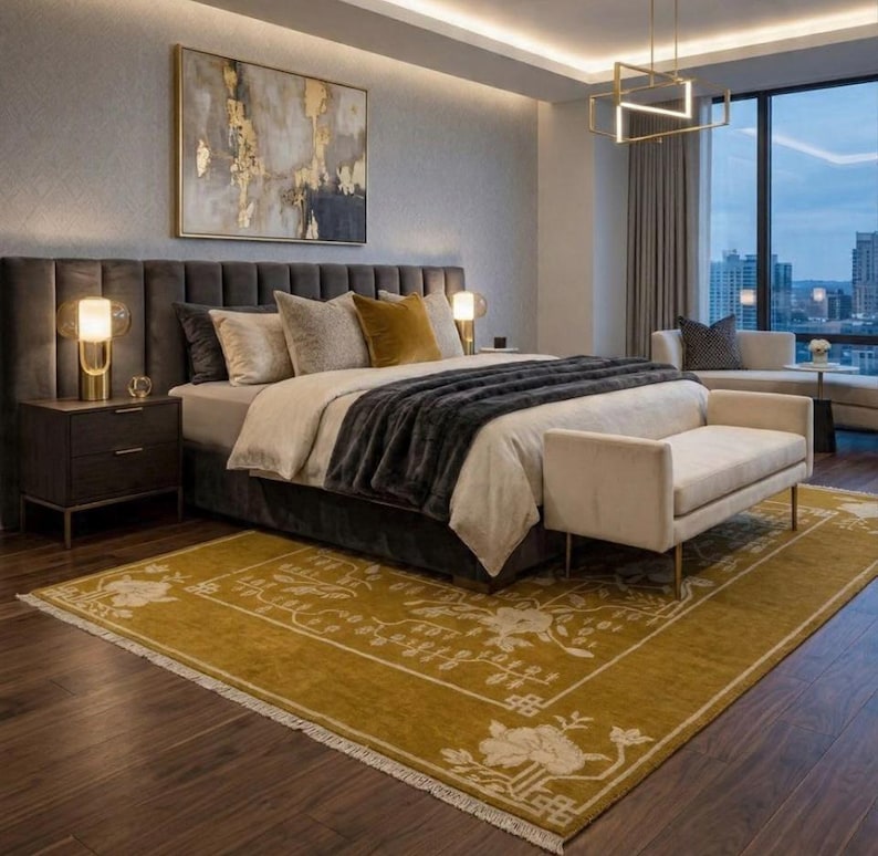 Pu&ograve; includere: Una lussuosa camera da letto con un letto grande, una testiera grigio scuro e una coperta grigia. Un tappeto color senape con un motivo floreale &egrave; posato sul pavimento in legno scuro. Una panca &egrave; ai piedi del letto e un dipinto &egrave; appeso sopra.