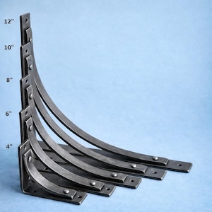 Puede incluir: Juego de cinco escuadras de estantería de metal oscuro de diferentes tamaños: 10 cm, 15 cm, 20 cm, 25 cm y 30 cm de altura. Cada escuadra presenta un brazo de soporte curvado y una base plana con agujeros pretaladrados para el montaje.