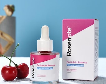 May include: A clear glass bottle of Rosenote Fruit Acid Essence with a white dropper, next to a matching box. The bottle and box have pink and white labels with text. Two red cherries sit in front of the bottle.