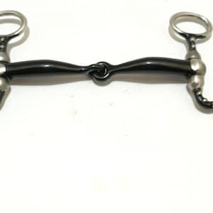 Peut inclure: Un mors de cheval avec un embout buccal noir et des anneaux et des accents décoratifs argentés. Le mors a un design incurvé avec une série de petits points argentés le long de la partie incurvée. Les anneaux sont circulaires.