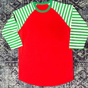 Bright Red Raglan Shirt with Curved Hem and Candy Cane Striped Arms in Green and White.