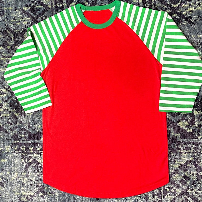 Bright Red Raglan Shirt with Curved Hem and Candy Cane Striped Arms in Green and White.