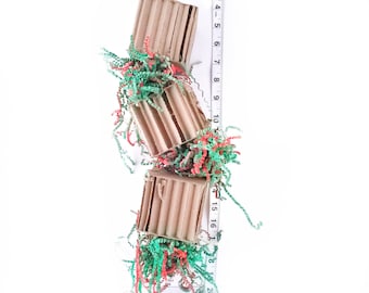 May include: A cardboard bird toy with three hanging sections, each filled with colorful shredded paper. The toy is approximately 20 inches long.