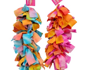 Könnte beinhalten: Zwei bunte, tie-dye-farbene Fleece-Hundespielzeuge mit den Worten "Cheep Thrills" auf den Etiketten.