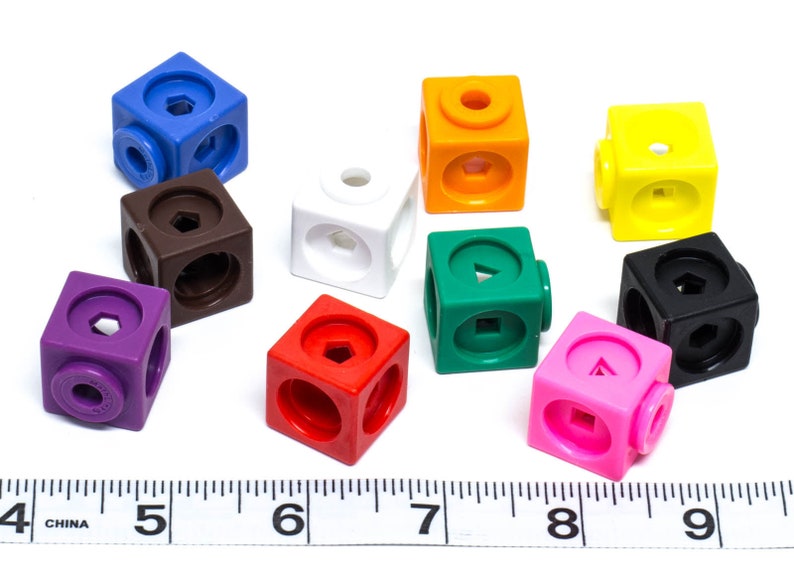 May include: A selection of brightly coloured plastic cubes in shades of blue, brown, white, purple, red, orange, green, yellow, black, and pink. Each cube features different geometric shapes and circular connectors.