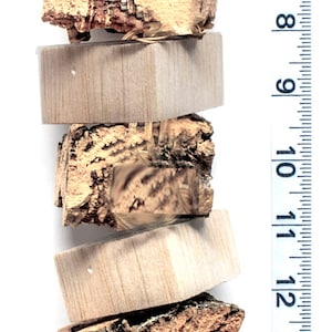 May include: A stack of five wooden chew toys for small pets. The toys are made of different types of wood, including bark and a light wood. The toys are tied together with a natural twine string.