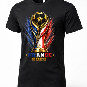 May include: Black t-shirt featuring a gold soccer ball trophy design with blue, white, and red accents. The text "FRANCE - 2026" is displayed below the trophy. The design is a celebration of soccer.