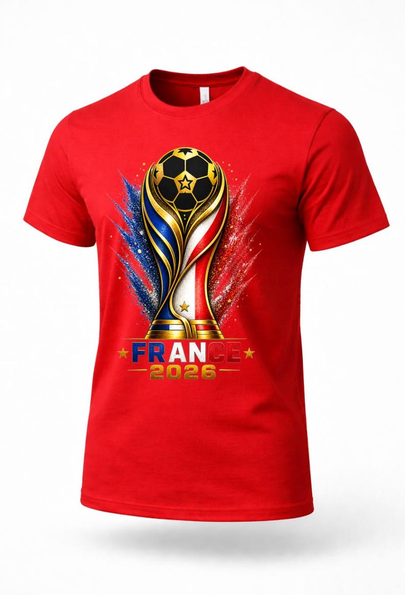 May include: Red t-shirt featuring a gold and black soccer ball trophy design with the text "FRANCE 2026". The design incorporates the colors of the French flag with blue, white, and red accents.