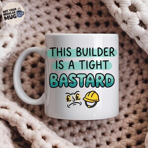 Könnte beinhalten: Ein weißer Keramikbecher mit dem schwarzen und blaugrünen Text THIS BUILDER IS A TIGHT BASTARD. Unter dem Text befinden sich Illustrationen eines mürrischen Gesichts mit Pfundzeichen als Augen und einem gelben Bauarbeiterhelm.
