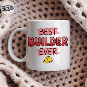 May include: A white ceramic mug featuring the text "BEST BUILDER EVER" in bold black and red lettering, accented by pink brushstroke highlights and a small yellow construction hard hat icon centred below the text on the front of the mug.