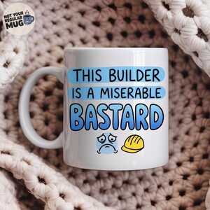 May include: A white ceramic mug featuring the blue text THIS BUILDER IS A MISERABLE BASTARD, accompanied by a sad blue face icon and a yellow hard hat icon. A circular logo in the top left corner reads NOT YOUR REGULAR MUG with a small blue mug icon.