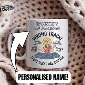 Op de afbeelding: Een witte keramische mok met een cartoonillustratie van een DJ achter een mengpaneel en de tekst HANNAH'S DJ EXCUSES, WRONG TRACK, SYNC WAS OFF, STILL HUNGOVER, DECKS PLAYED UP, CROWD'S DEAD en THESE DECKS ARE CURSED op de voorzijde.