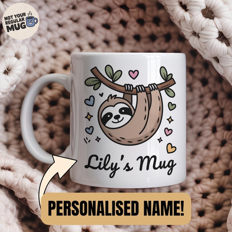 May include: White ceramic mug featuring a cartoon sloth hanging from a branch, surrounded by hearts and stars. The mug has the text "Lily's Mug" and "PERSONALIZED NAME!" in a playful font. The mug has a white handle and a white background.