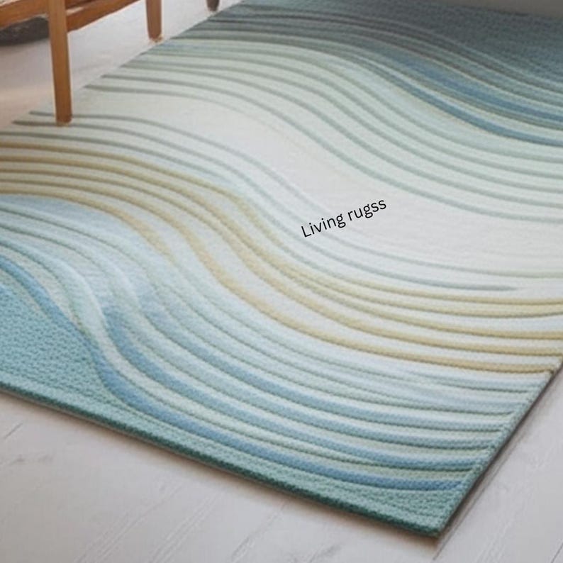 K&ouml;nnte beinhalten: Rechteckiger Teppich mit wellenf&ouml;rmigem Muster in Blau-, Wei&szlig;- und Beiget&ouml;nen. Der Teppich hat eine strukturierte Oberfl&auml;che und der Text "Living rugss" ist sichtbar. Der Teppich liegt auf einem hellen Boden.