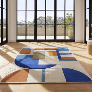 May include: A rectangular rug with a geometric pattern in shades of blue, orange, green, and white. The rug is displayed on a wooden floor, in a room with large windows overlooking a natural landscape.