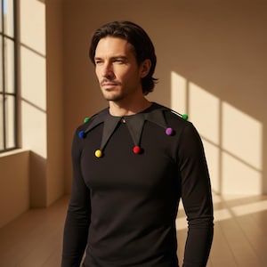 May include: A black long-sleeve shirt with a black jester collar. The collar is adorned with colorful pom-poms in red, yellow, green, blue, and purple. The jester collar is a fun and festive accessory.