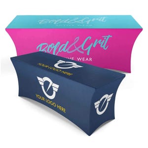 May include: Two fitted table covers. The front cover is navy blue with a white logo and the text "YOUR LOGO HERE". The background cover is pink with the text "Bold & Grit ACTIVE WEAR" in light blue.