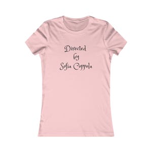以下が含まれることがあります： 胸の中央にスタイリッシュなセリフ体で「Directed by Sofia Coppola」という黒い文字がプリントされた、ライトピンクの半袖Tシャツ。クルーネックで、標準的なフィット感の半袖デザインとなっています。