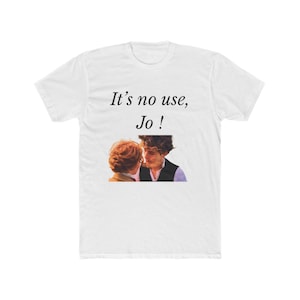Könnte beinhalten: Ein weißes Kurzarm-T-Shirt mit dem schwarzen Aufdruck It's no use, Jo ! über einem rechteckigen Foto-Aufdruck, der zwei Personen mit rotbraunem und dunkelbraunem Haar zeigt, die sich in einem intimen Moment gegenüberstehen.