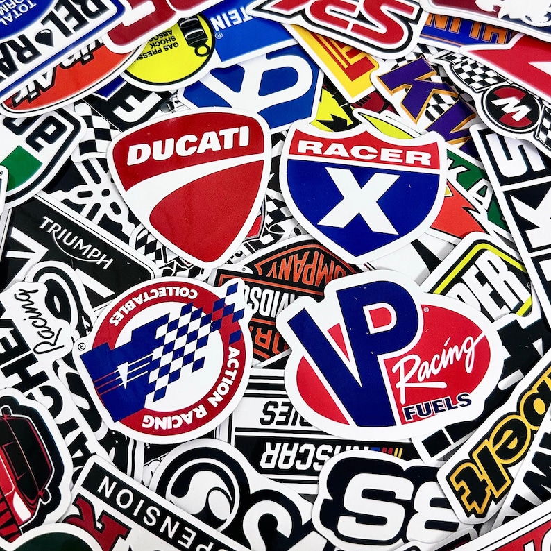 May include: A collection of colorful racing and automotive-themed stickers. The stickers feature various logos, including "Ducati," "Racer X," and "VP Racing Fuels." The designs incorporate red, white, blue, and black, with bold typography and graphic elements.