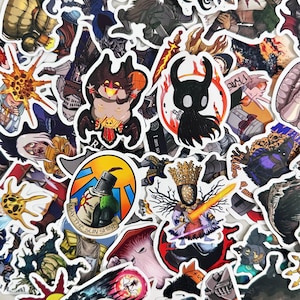 May include: A selection of vibrant stickers showcasing fantasy characters and designs. The stickers depict knights, demons, and other fantastical creatures. Some stickers include text, such as "May the Sun Shine".