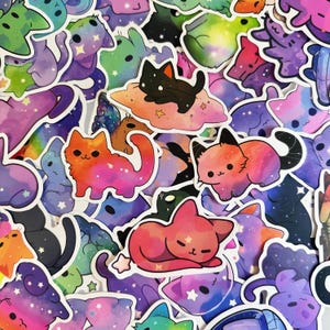 K&ouml;nnte beinhalten: Eine Sammlung bunter Katzenaufkleber mit Galaxiethema. Die Aufkleber zeigen verschiedene Katzendesigns in Rosa-, Orange-, Lila- und Blaut&ouml;nen mit Sternen- und Wolkenakzenten. Geeignet zum Dekorieren von Laptops, Wasserflaschen oder Notizb&uuml;chern.