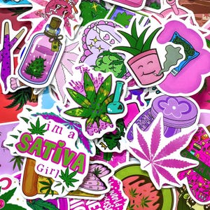 Könnte beinhalten: Eine Sammlung farbenfroher Aufkleber mit Designs zum Thema Cannabis. Die Aufkleber zeigen Bilder von Marihuanablättern, Bongs und Sätzen wie "I'm a Sativa Girl". Die Farbpalette umfasst Pink, Grün, Lila und Weiß.