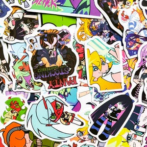 Puede incluir: Una colecci&oacute;n de pegatinas coloridas de estilo anime con varios personajes. Las pegatinas muestran una variedad de dise&ntilde;os, incluyendo personajes con pelo largo, atuendos &uacute;nicos y paletas de colores llamativas. Algunas pegatinas tienen texto, incluyendo "Panty & Stocking with Garterbelt."