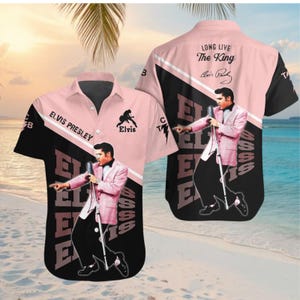 May include: Pink and black short-sleeve button-down shirt featuring an image of Elvis Presley. The shirt has the text "ELVIS PRESLEY" and "LONG LIVE The King" with Elvis's signature. The design includes a silhouette of Elvis.