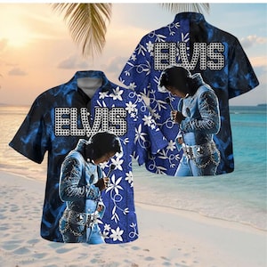 Op de afbeelding: Blauw Hawaiiaans shirt met een afbeelding van Elvis Presley. Het shirt heeft een blauw en zwart tie-dye patroon, de naam "ELVIS" in witte blokletters, een bloemenpatroon en een afbeelding van Elvis. Korte mouwen.