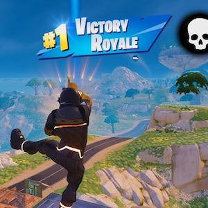 May include: A video game scene with a player celebrating a victory. The image displays the text "#1 Victory Royale" and a skull icon with the number "20". The player is wearing a black and orange outfit, set against a backdrop of mountains and a blue sky.