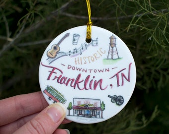 Franklin TN Ornament, ceramic ornament with gold string, featuring The Factory, the trolley, The Franklin Theater, a historic cannon, etc
