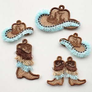 Puede incluir: Cinco parches bordados con temática western. Los parches son marrones con flecos azules y representan sombreros de vaquero y botas.