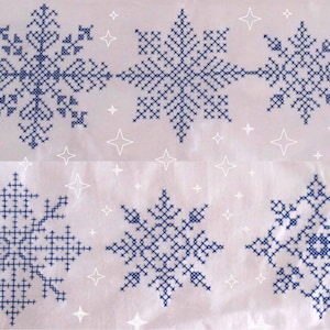 May include: Six blue snowflake embroidery designs on a white fabric background. The snowflakes are all different designs and are arranged in two rows of three.