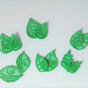 Puede incluir: Siete hojas de tela verde con diseños intrincados, perfectas para manualidades o decoración.